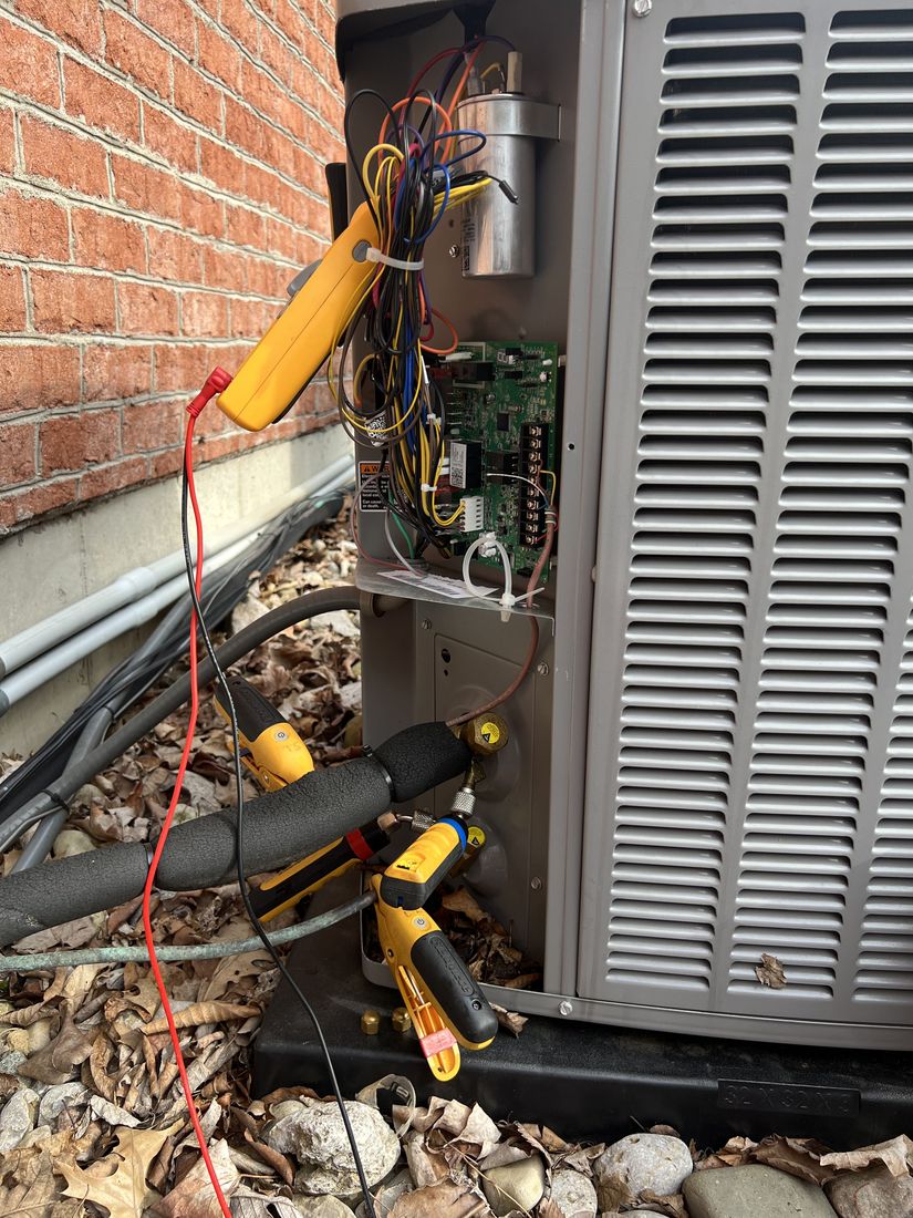Gauges and a meter connected to the open control panel of an outdoor unit