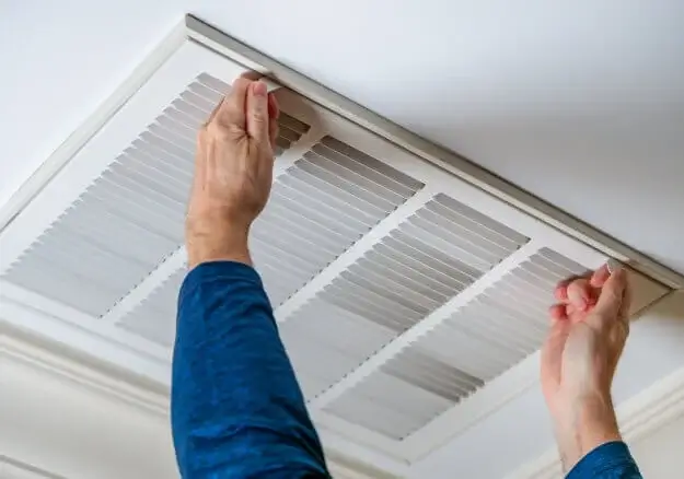 Man opening duct on ceiling